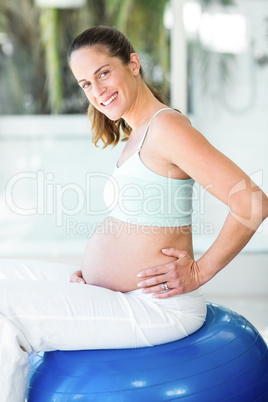 Portrait of happy woman sitting on exercising ball