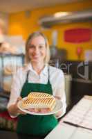 Female shop owner serving sandwich