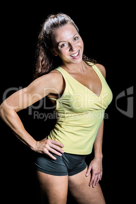 Portrait of happy athlete with hand on hip