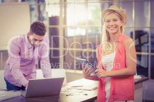 Businesswoman with digital tablet by male colleague working on l