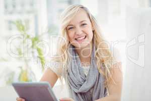 Portrait of happy woman holding digital tablet