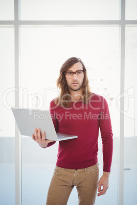 Portrait of creative businessman holding laptop