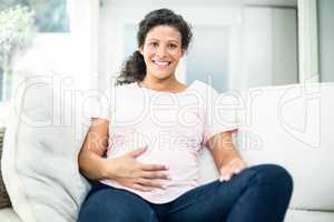 Happy pregnant woman touching belly