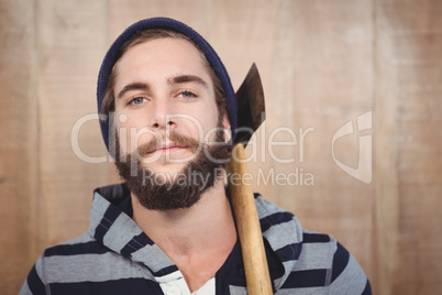 Close-up portrait of hipster with hooded shirt holding axe