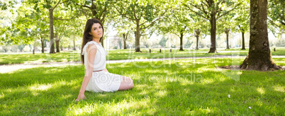 Young woman sitting on grassland in park