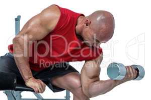 Bald man exercising with dumbbells while sitting on bench press