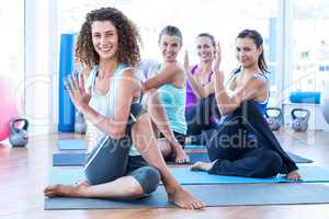Portrait of cheerful women doing spine twisting pose