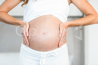 Midsection of woman touching belly