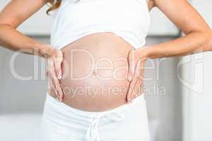 Midsection of woman touching belly