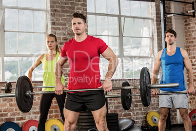 Focused people lifting barbell