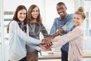 Portrait of smiling business team putting their hands together