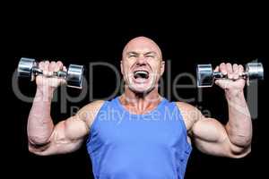 Aggressive man lifting dumbbells