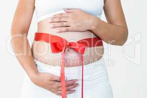Close-up of pregnant woman with red ribbon