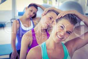 Portrait of a cheerful woman doing head exercise with friends