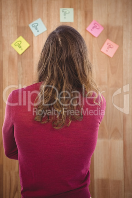 Man standing in front of sticky notes stuck on wooden wall