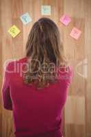 Man standing in front of sticky notes stuck on wooden wall