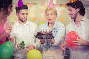 Businesswoman blowing birthday candles