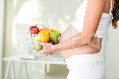 Side view of woman holding fruit bowl