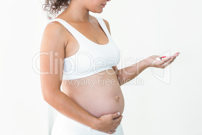 Pregnant woman holding pills