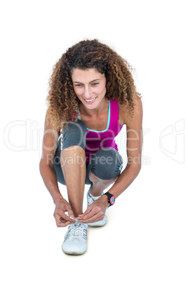 Happy young woman tying shoelace