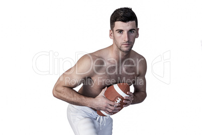 Portrait of shirtless rugby player posing with the ball