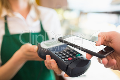 Female worker accepting payment through NFC