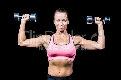 Portrait of smiling woman lifting dumbbells