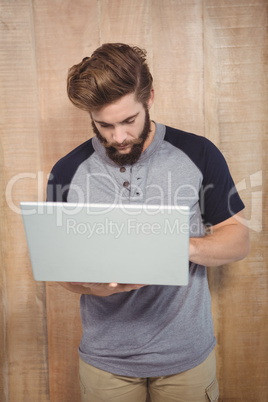 Hipster working on laptop while standing