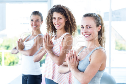 Portrait of women smiling with hands joined