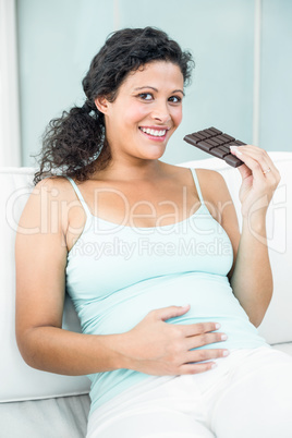 Portrait of happy woman with chocolate bar