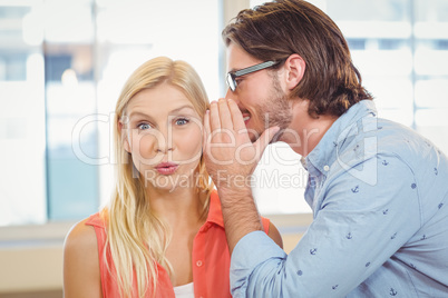 Businesswoman listening to rumor which male colleague is whisper