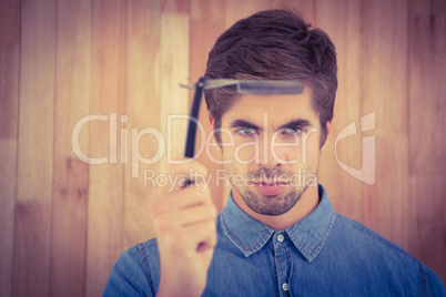 Portrait of serious hipster holding straight edge razor