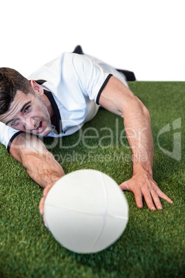 Man holding rugby ball while lying down