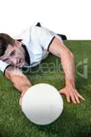 Man holding rugby ball while lying down