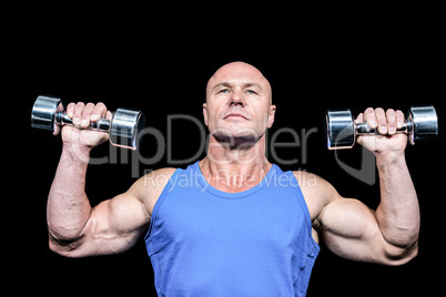 Muscular man in vest lifting dumbells