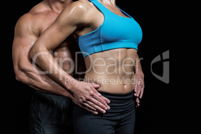 Midsection of healthy couple with hands on hip