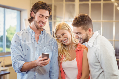 Handsome businessman showing something on smart phone to colleag