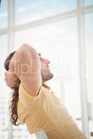 Hipster relaxing against window in office