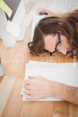 High angle view of tired hipster resting at desk