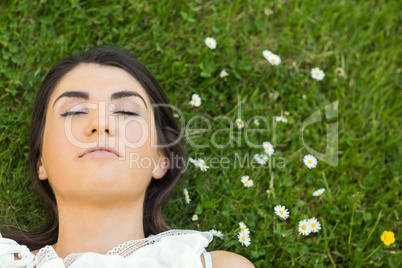 Beautiful young woman relaxing on grassland