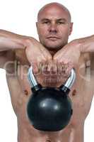 Portrait of confident man lifting kettlebell