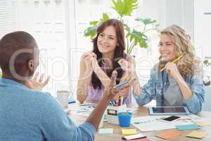 Happy business people discussing while working at desk