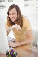 Hipster smiling while working on computer