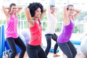 Portrait of smiling women exercising with hands behind head
