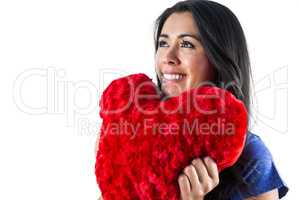 Smiling woman holding a heart shaped pillow