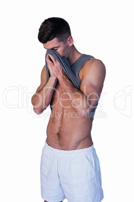 Man wiping his face with shirt
