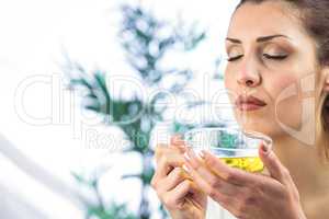 Woman smelling herbal tea with eyes closed