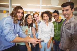 Businessman showing phone to happy colleagues