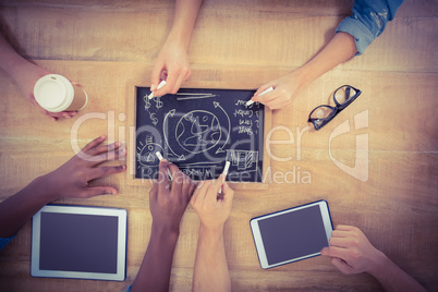 Overhead view of cropped hands writing business terms on slate w