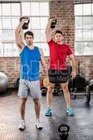 Portrait of muscular men lifting kettlebell
